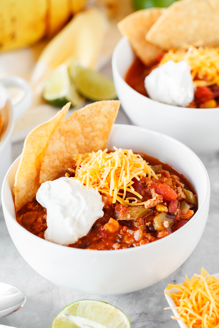 30 Minute Taco Soup topped with tortilla chips, sour cream, and cheddar cheese