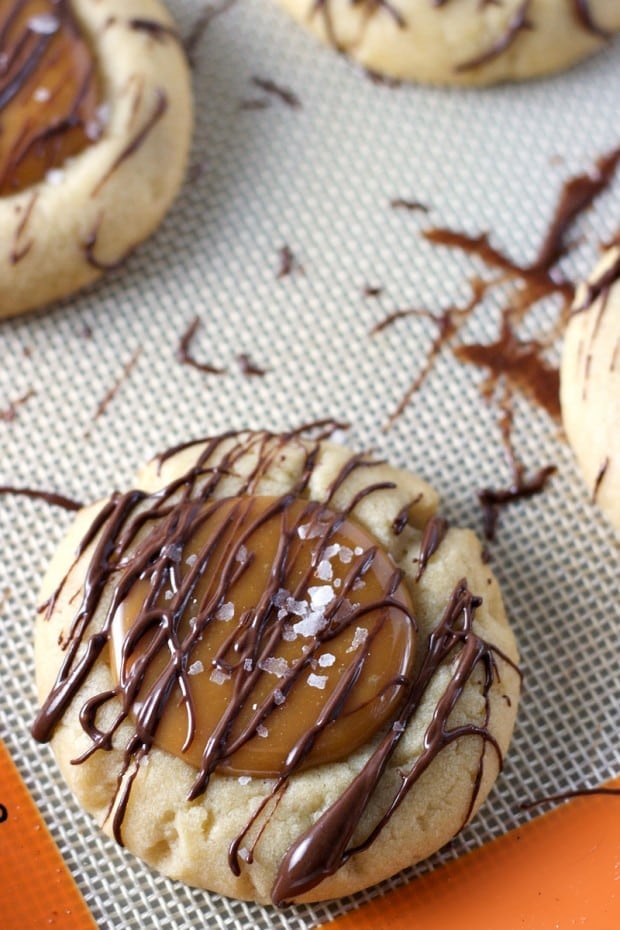 Salted Caramel Thumbprint Cookies - A soft sugar cookie filled with salted caramel and drizzled with melted semi sweet chocolate. 