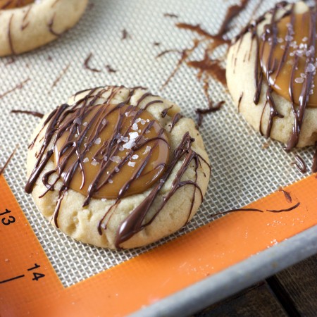 Salted Caramel Thumbprint Cookies - A soft sugar cookie filled with salted caramel and drizzled with melted semi sweet chocolate.