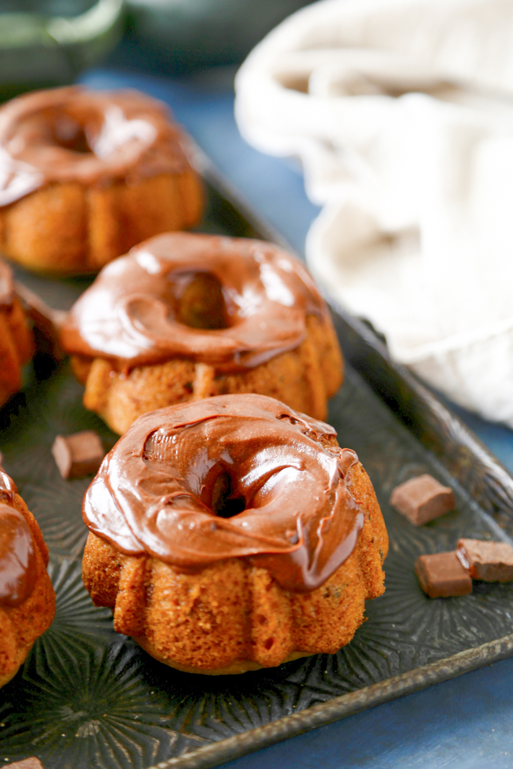 These Mini Spice Zucchini Bundt Cakes are a delicious way to celebrate the fall season!  Top with a delicious chocolate frosting and these little cakes can't be beat!
