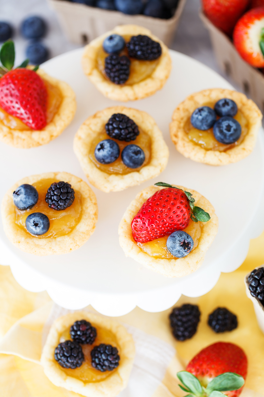 Sugar Cookie Lemon Tarts: a yummy sugar cookie tart filled with lemon curd, topped with fresh berries, and baked in a mini muffin tin. 