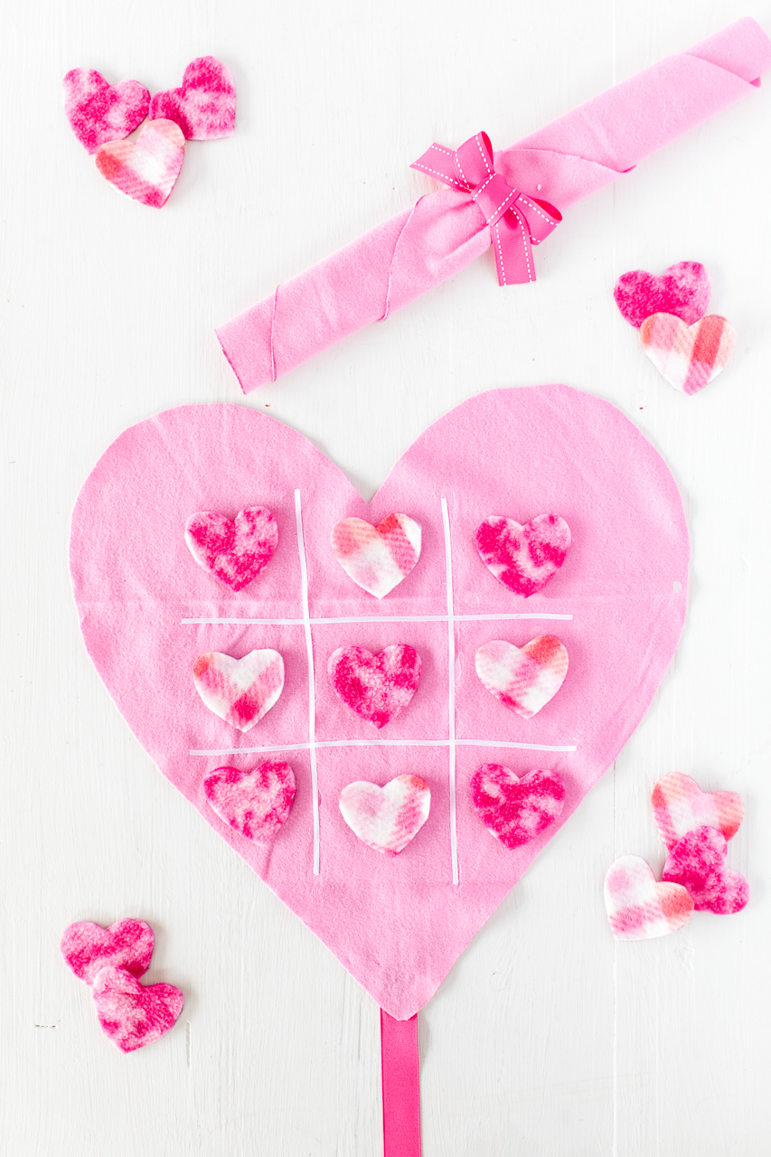 DIY Tic Tac Toe Game: a simple and fun no sew craft that the kids will love! It's a fun twist on the classic tic tac toe game perfect for Valentine's day! Felt, ribbon, and fleece hearts are all you need to complete this simple game! 