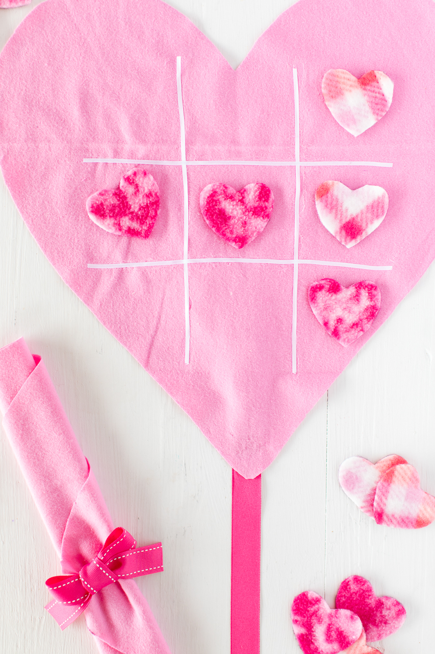 DIY Tic Tac Toe Game: a simple and fun no sew craft that the kids will love! It's a fun twist on the classic tic tac toe game perfect for Valentine's day! Felt, ribbon, and fleece hearts are all you need to complete this simple game! 