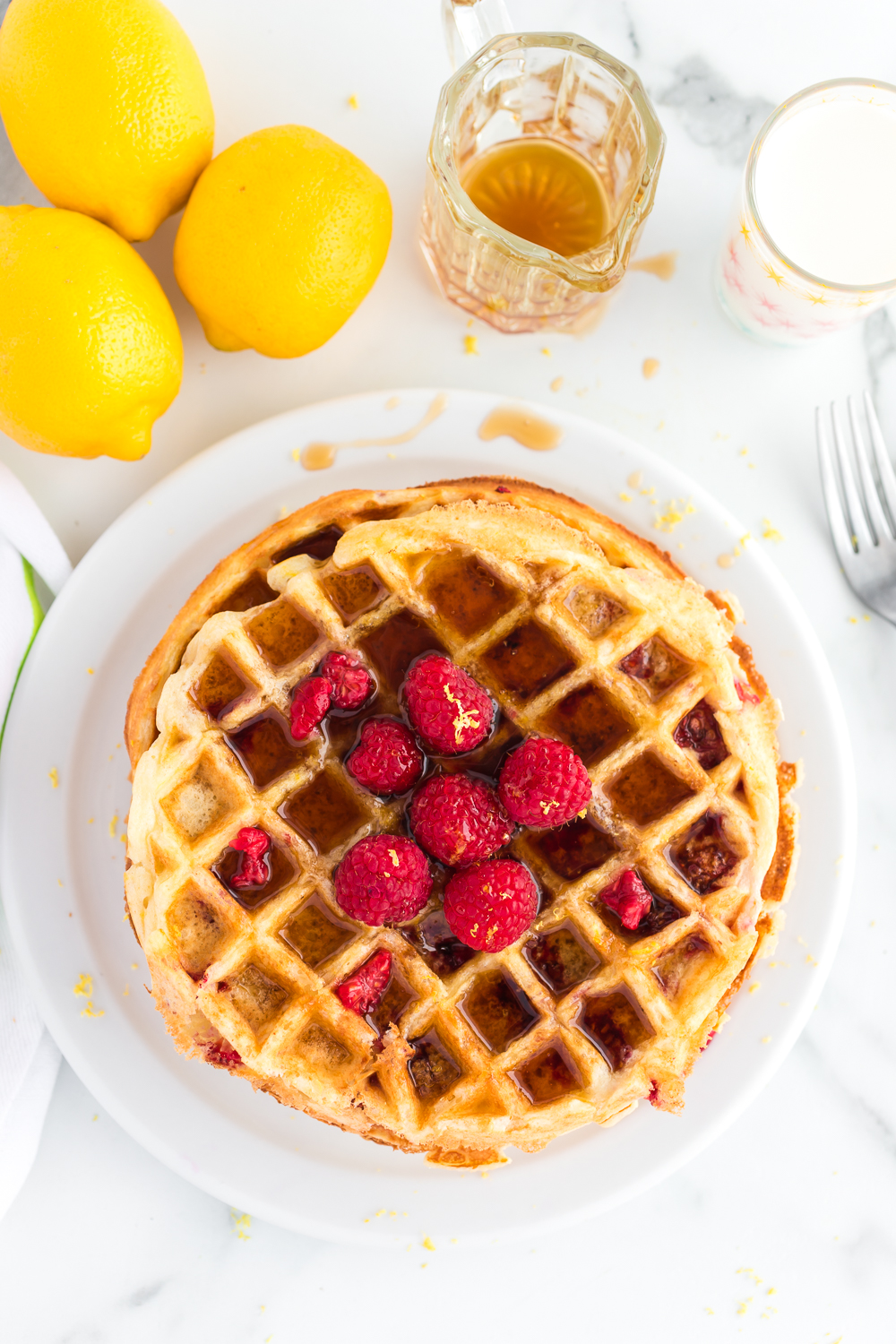 Lemon Raspberry Waffles: a delicious breakfast waffle that is bursting with a fresh lemon flavor and bits of raspberries in every bite. 