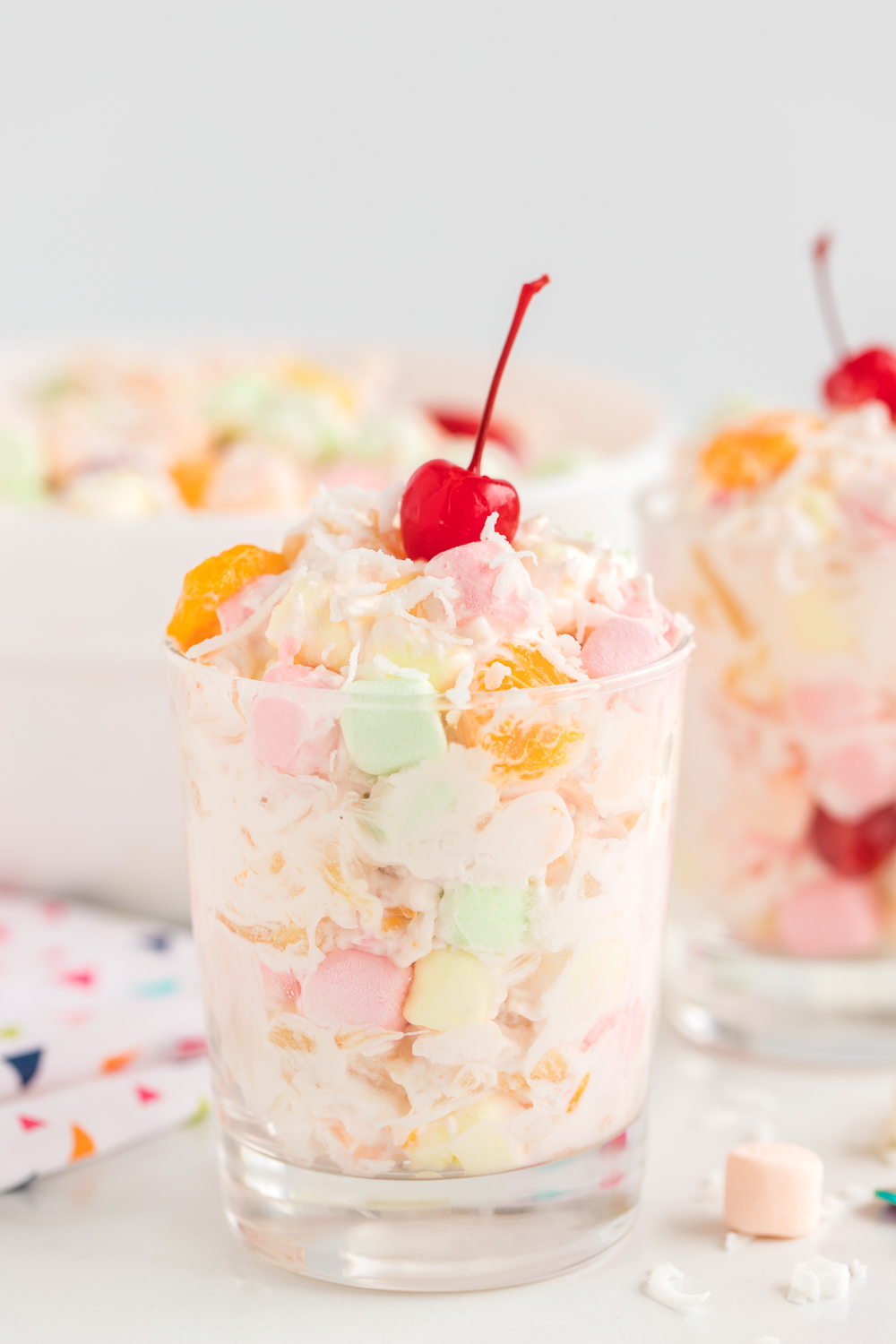 Ambrosia Fruit Salad: a simple and delicious fruit salad that is combined with sweet whipped topping and sprinkled with shredded coconut. Great for large gatherings, picnics and more!