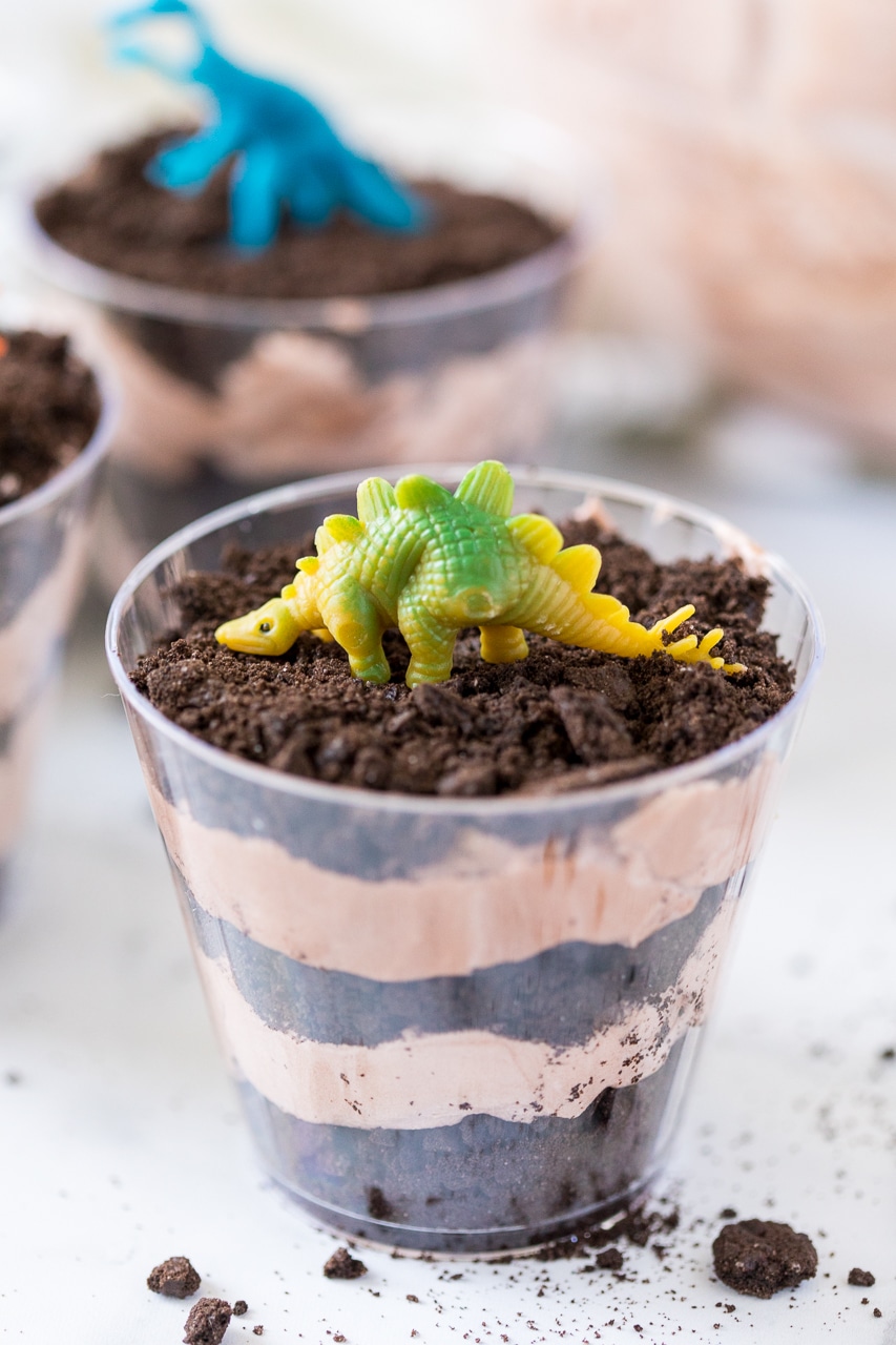 Dinosaur Dirt Cups: chocolate pudding and crushed Oreo cookies makes for a delicious layered chocolate dessert. Top it with a kid friendly dinosaur and you have a yummy and fun treat for any dino loving kid. 