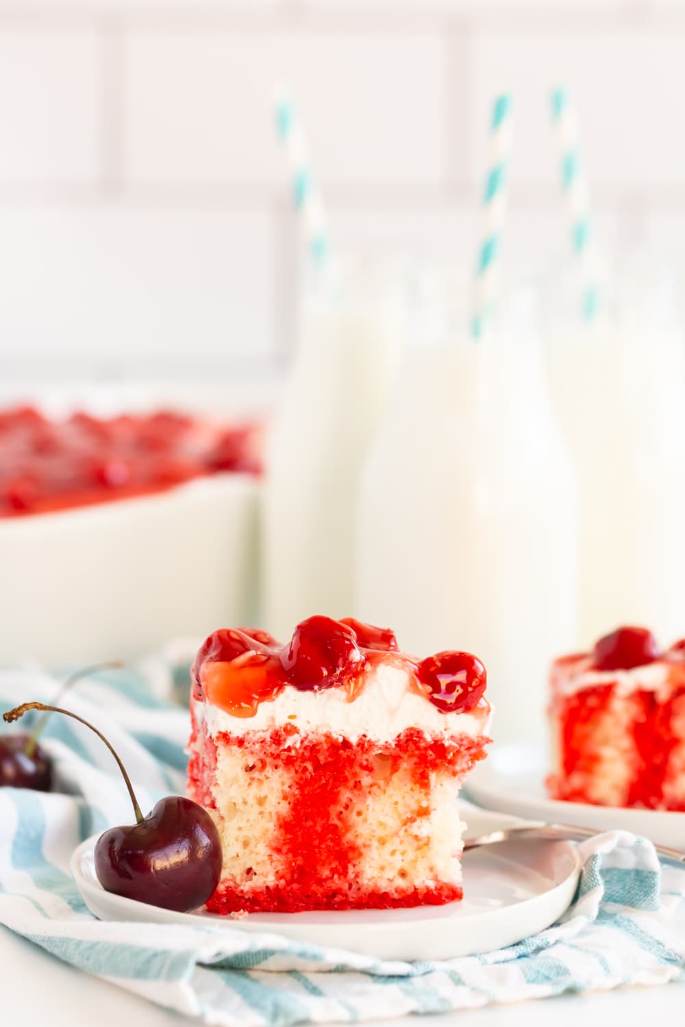 Cherry Poke Cake on Plate served with milk