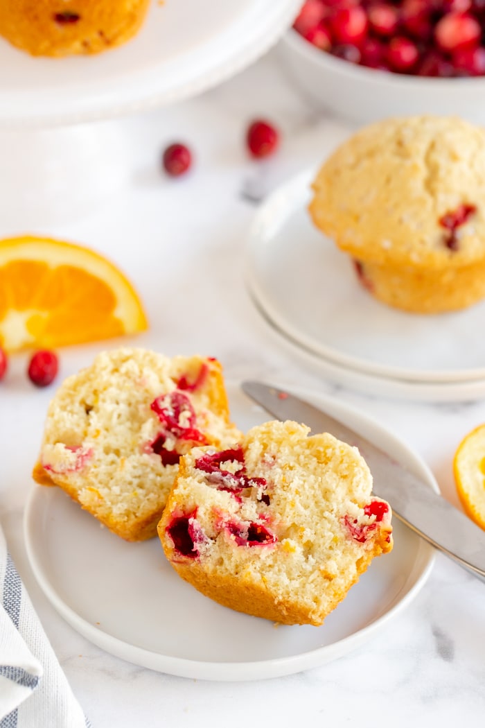 orange cranberry muffin cut in half place on white serving plate
