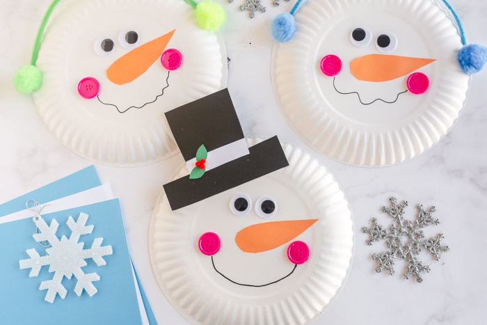 three paper plate snowmen with snowflakes