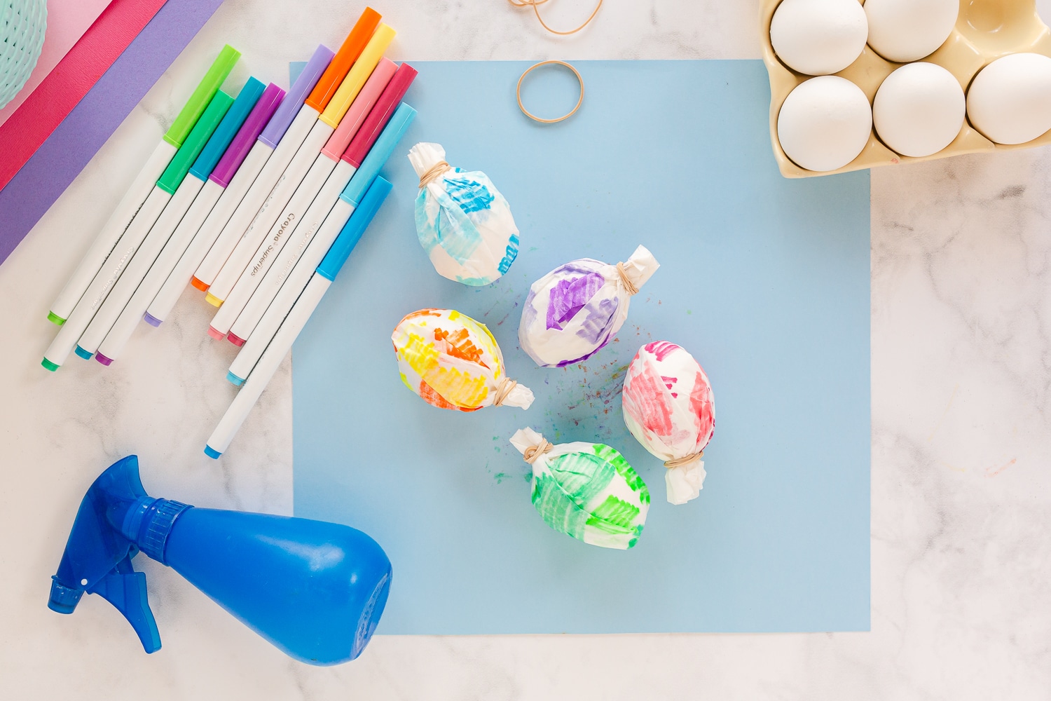 wrap hardboiled eggs in colored paper and secure with rubber band