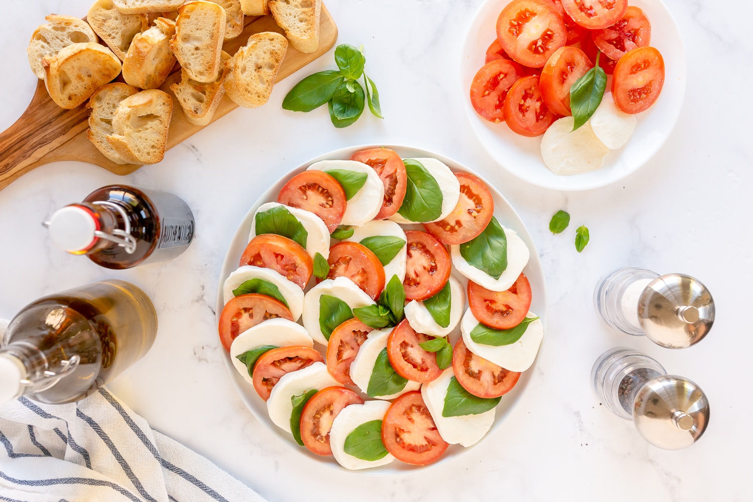 layer mozzarella cheese, tomatoes, and basil on platter
