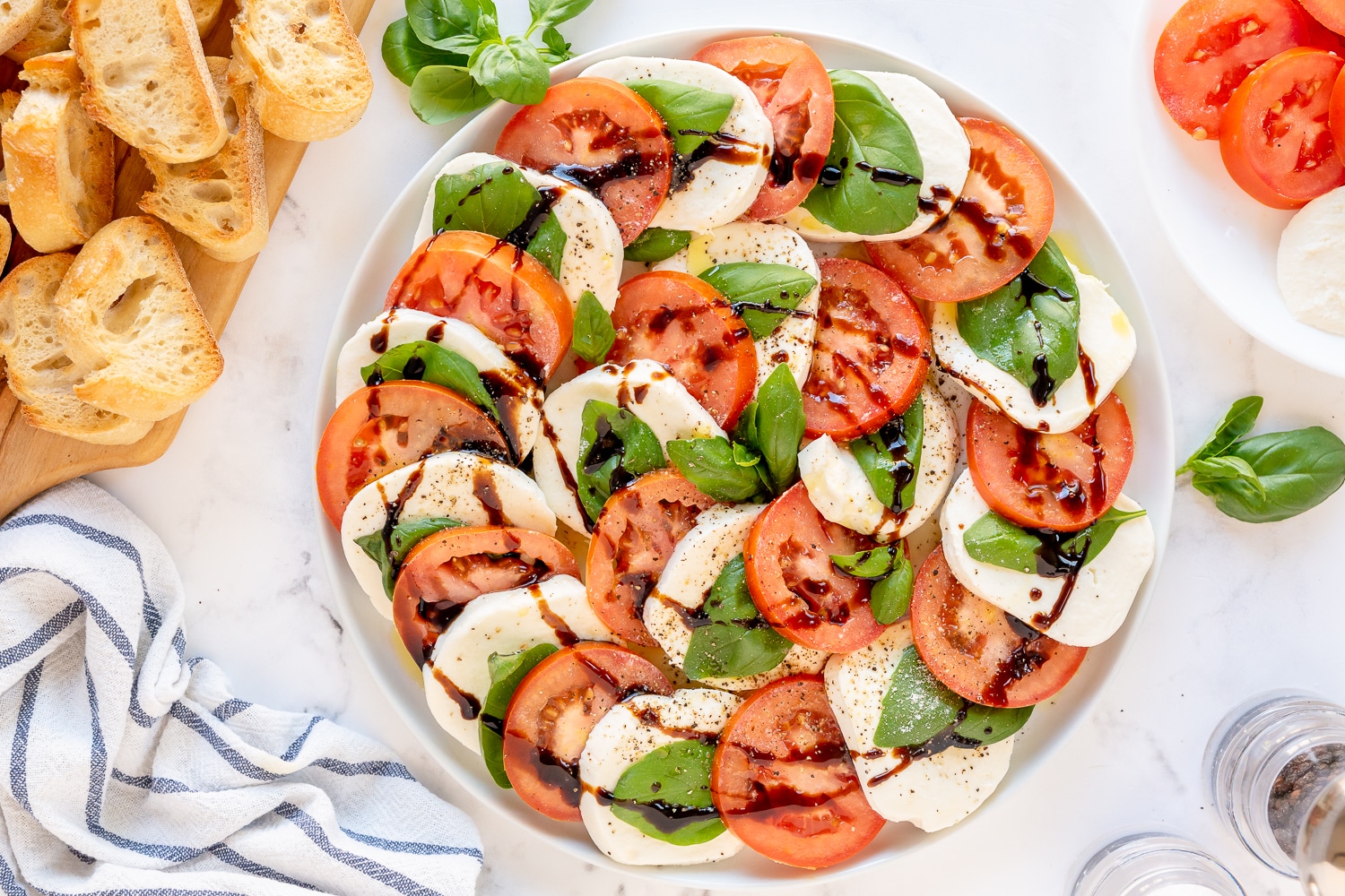 tomatoes, mozzarella cheese and basil on a platter