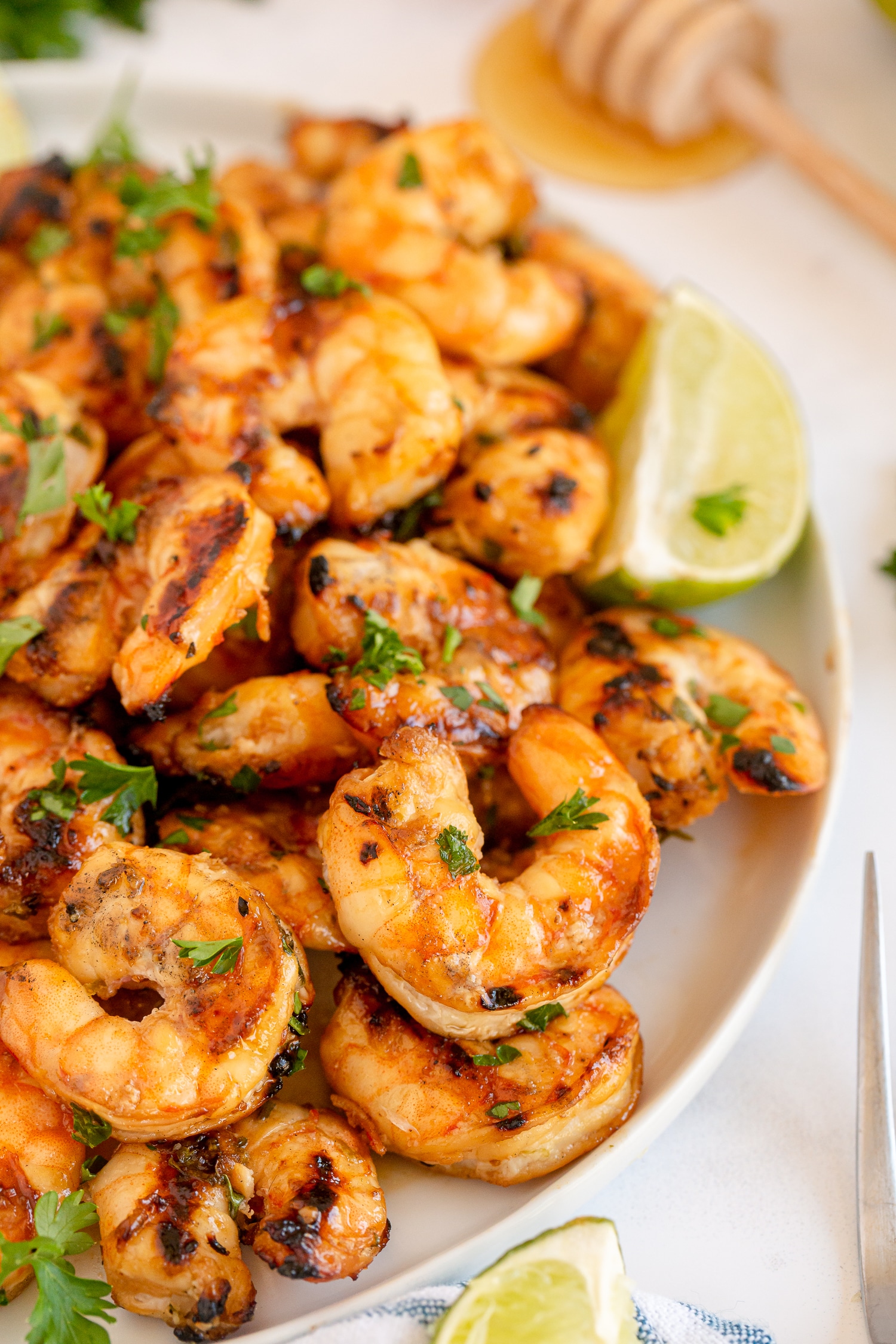 garlic honey lime shrimp on plate with lime wedges