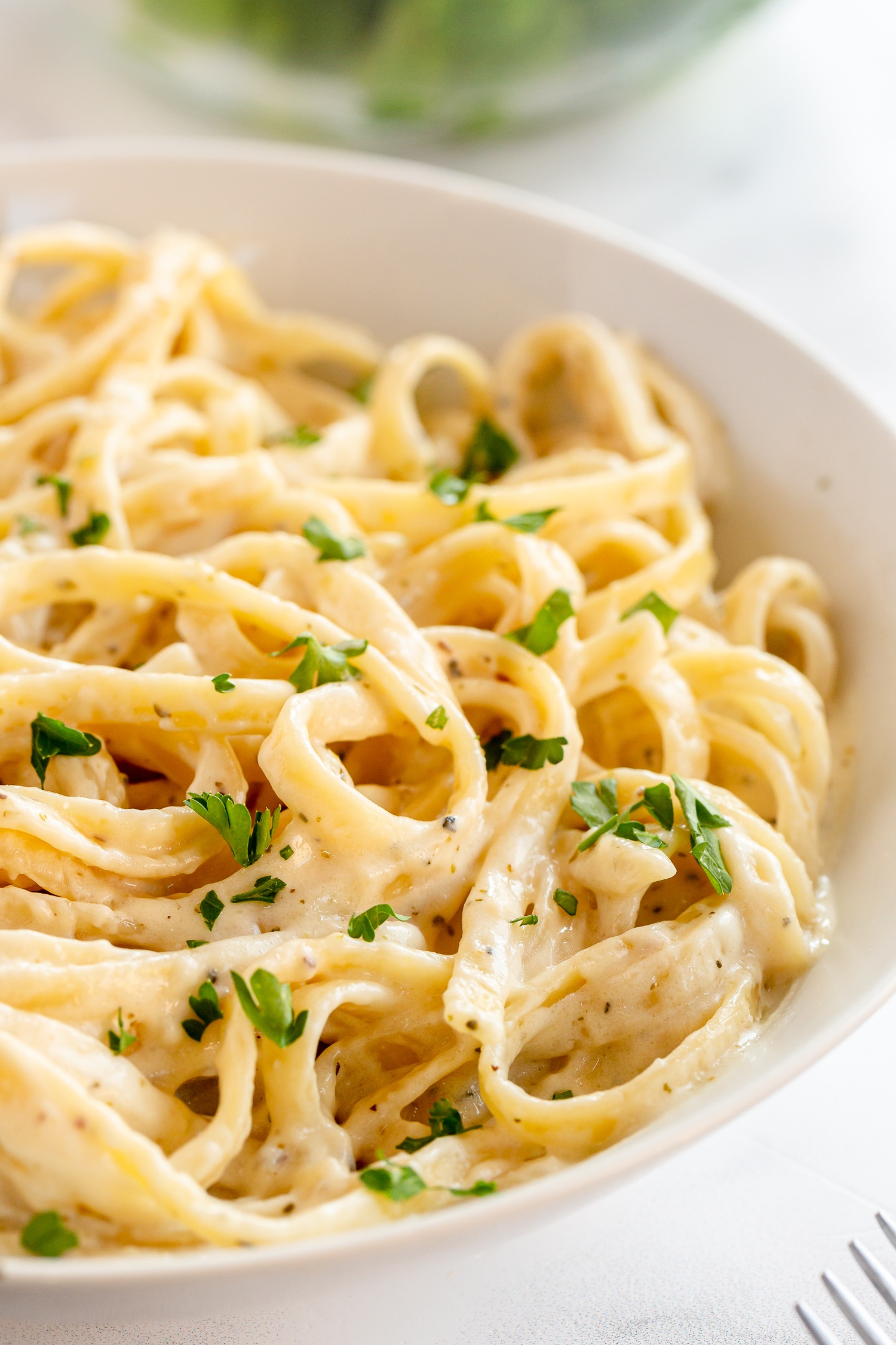 Homemade Alfredo in serving dish with parsley