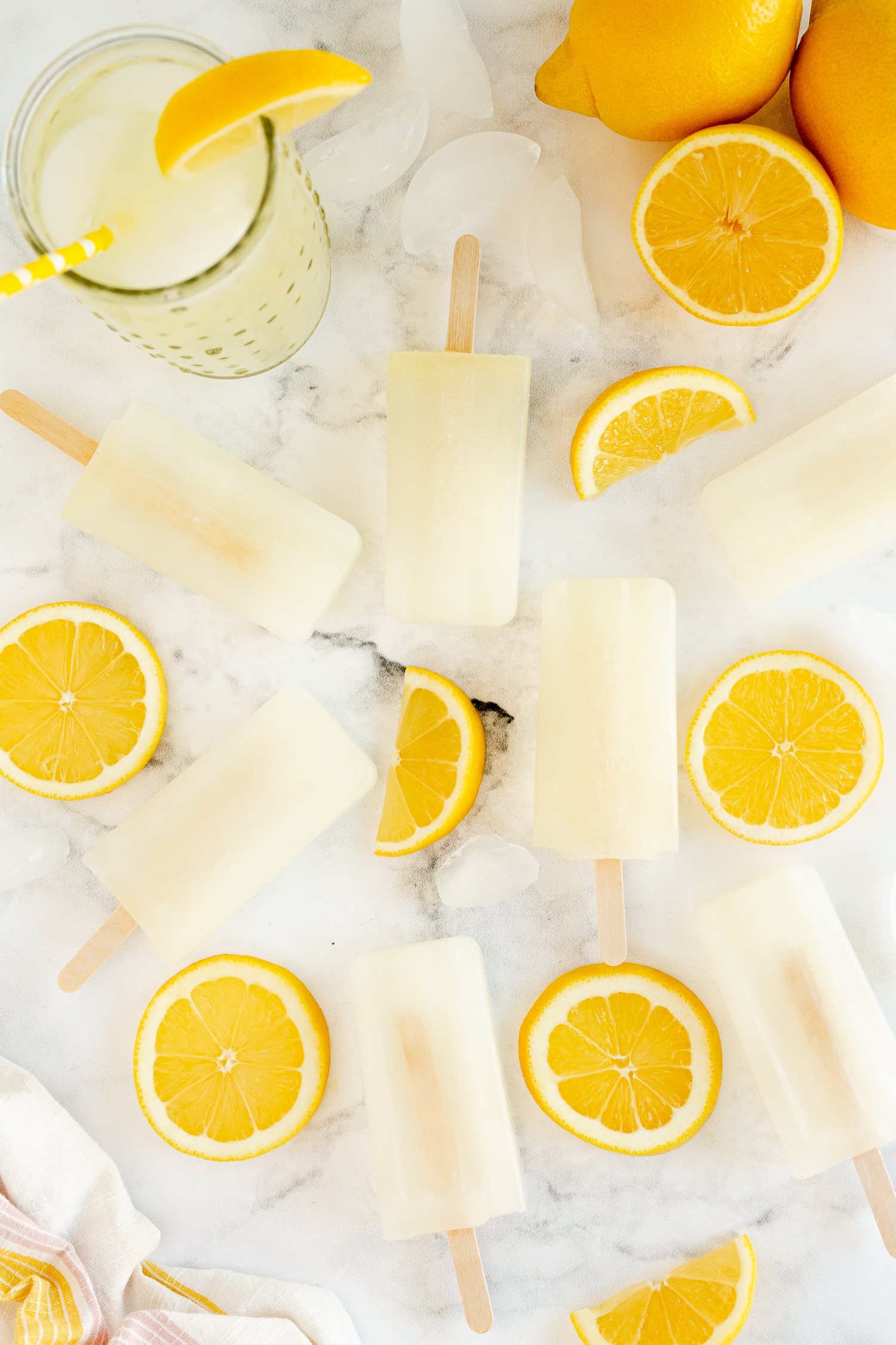 lemonade popsicles on marble counter with lemon slices