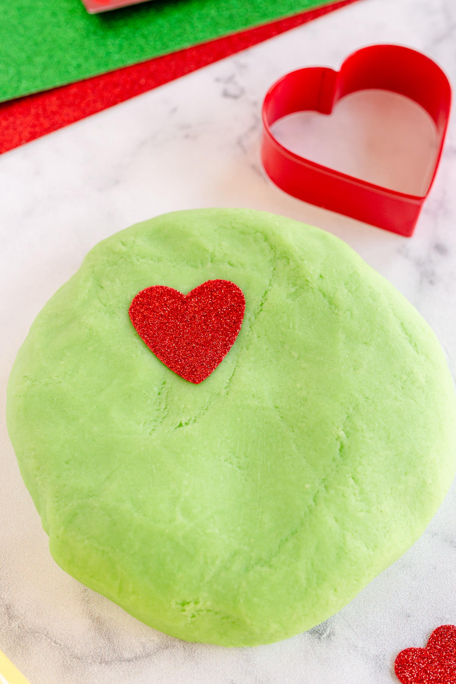 green playdough with red foam heart