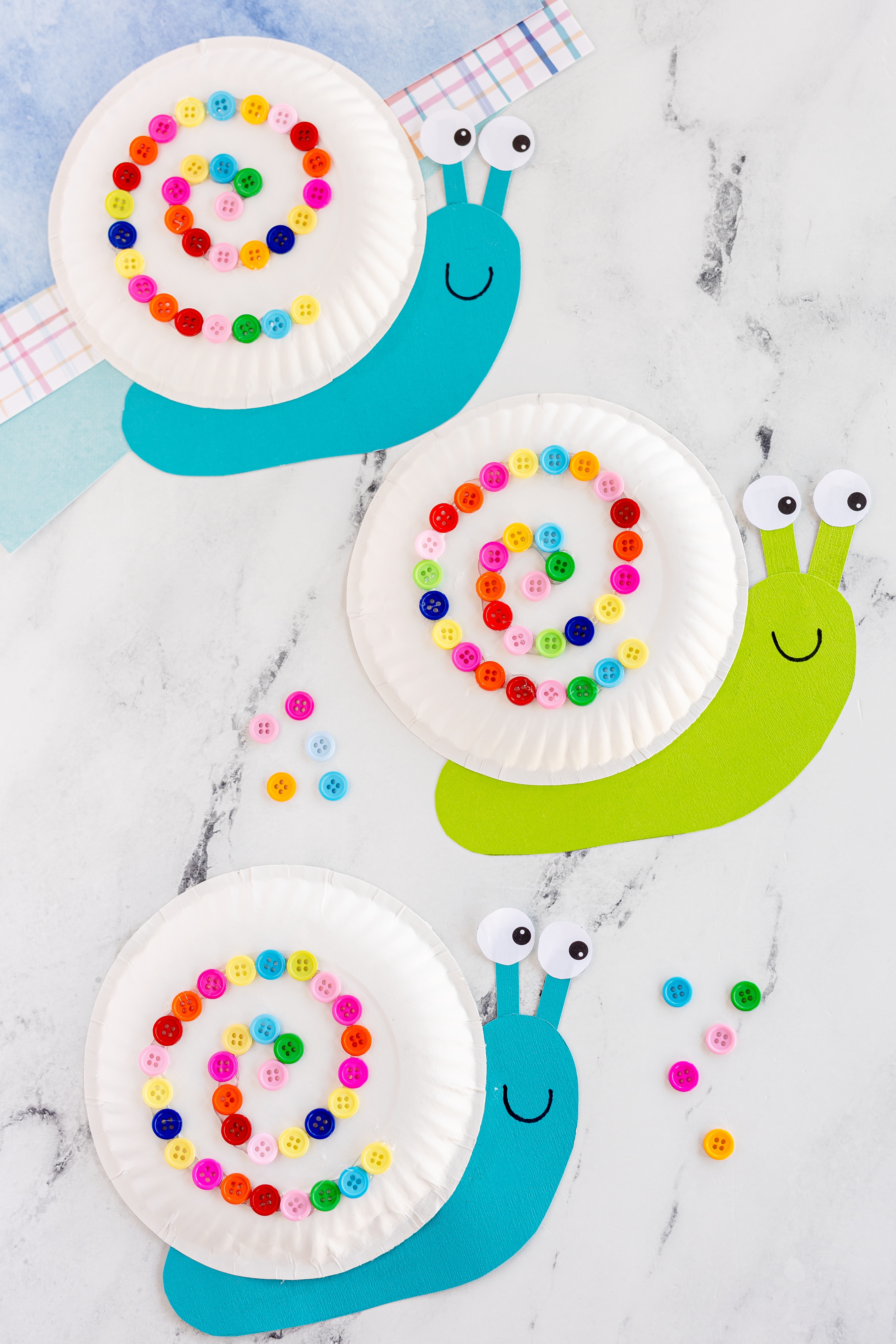 three finished paper plate snails on counter