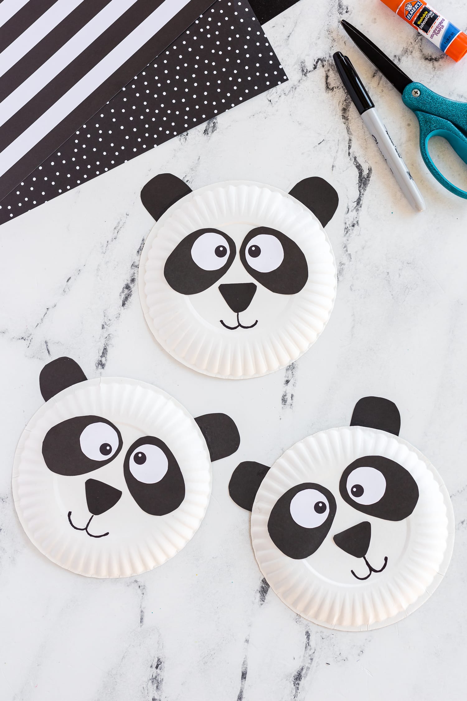 Three paper Plate panda crafts on counter
