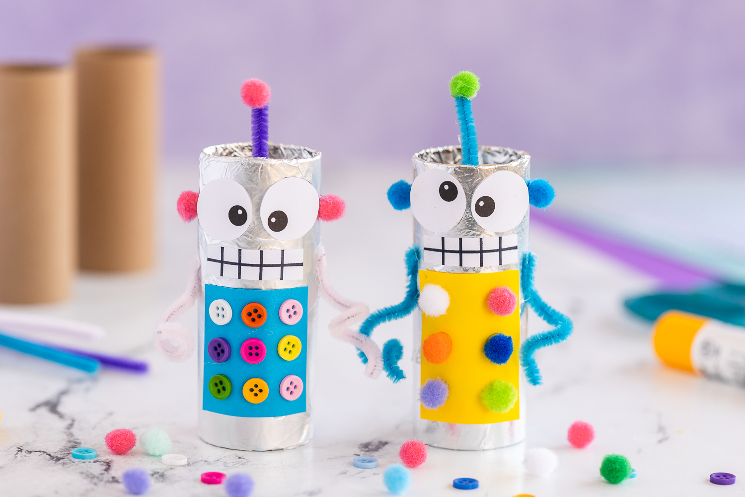 blue and yellow toilet paper roll robots standing up on white kitchen counter