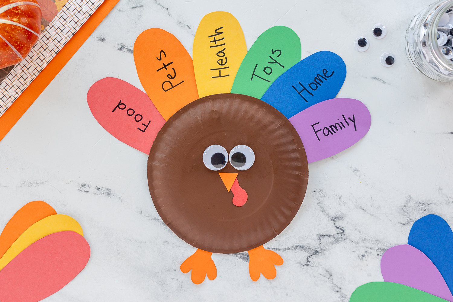 paper plate turkey painted brown with colorful paper feathers