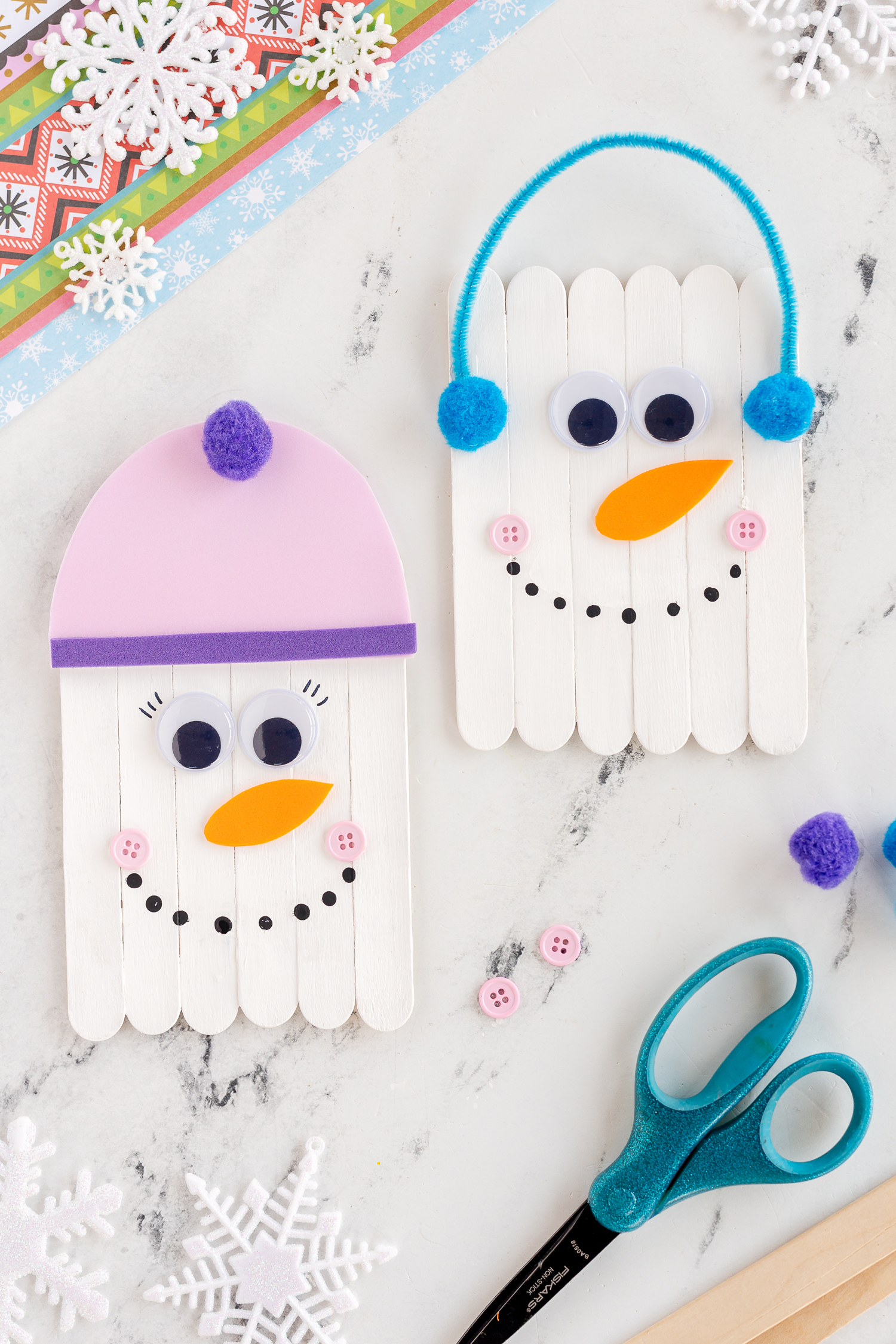 Popsicle Stick Snowman Craft on white marble counter