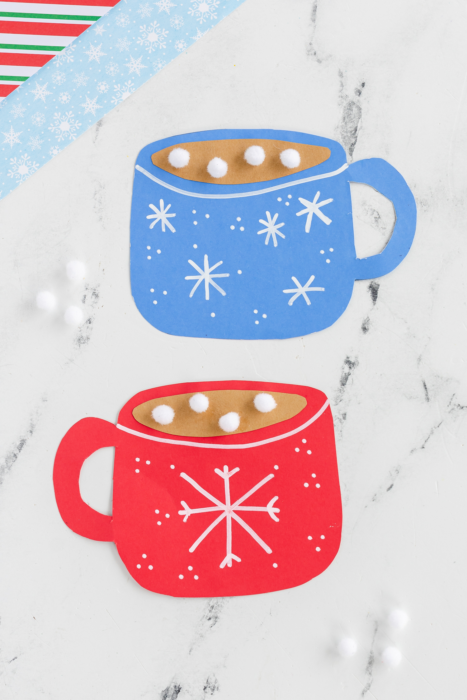 hand drawn white snowflakes on blue and red paper mugs