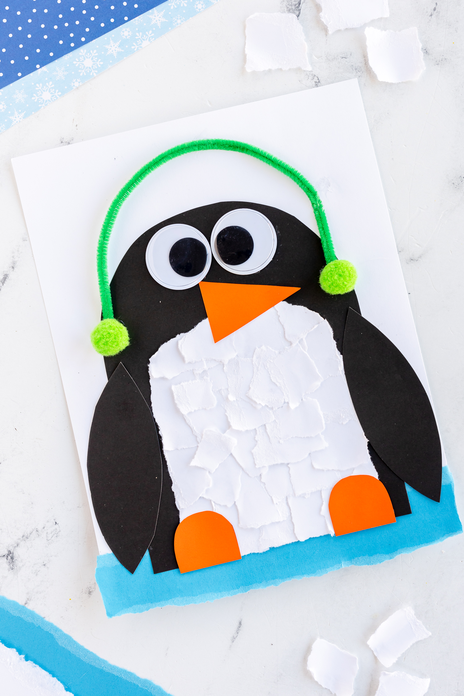 torn paper penguin craft on counter