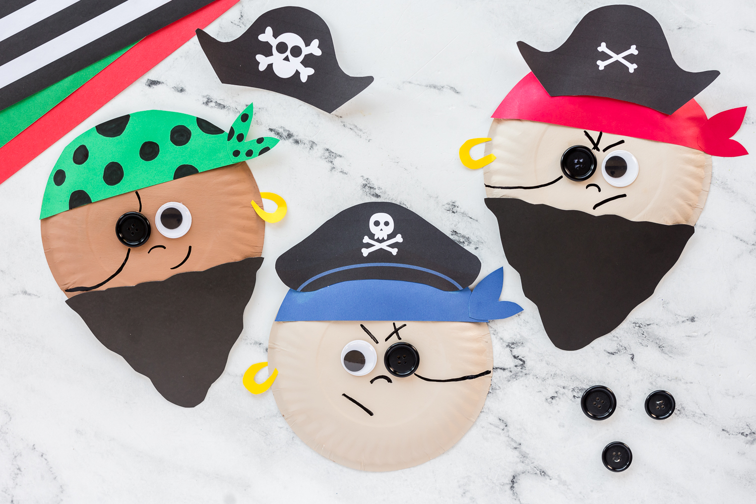 three paper plate  pirates on counter with extra buttons beside