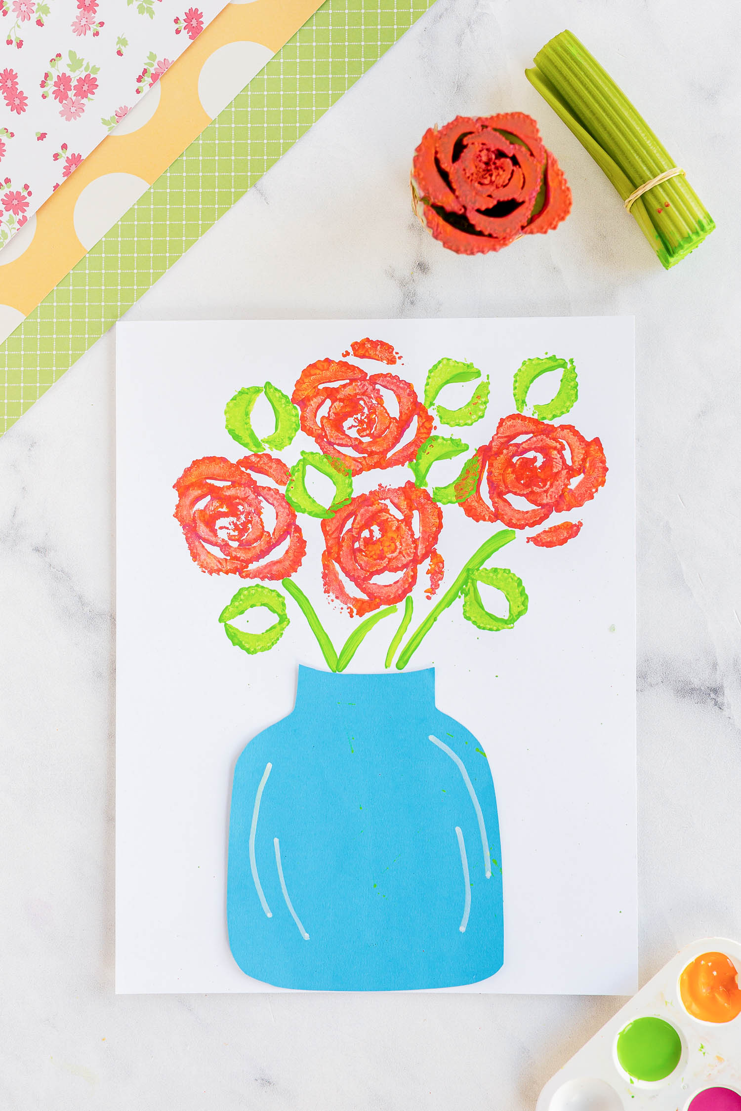 stamped celery flowers with blue vase and on craft counter