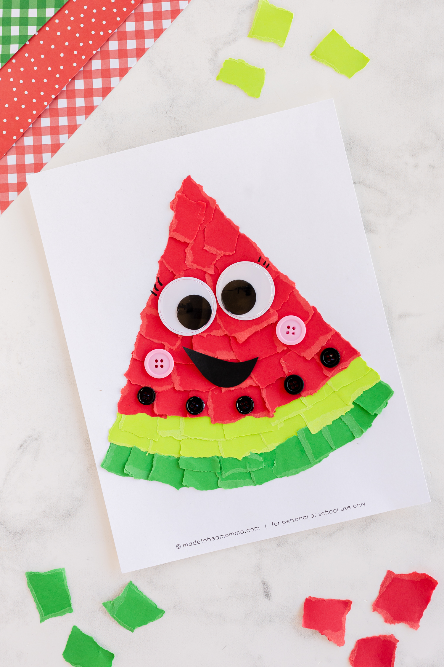 torn paper watermelon art on counter with large googly eyes
