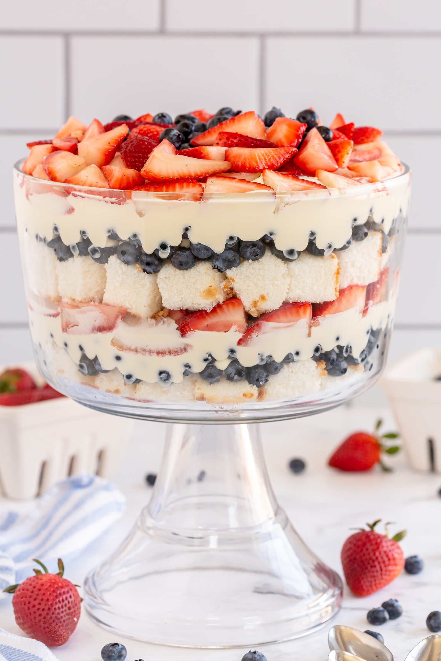 layers of blueberries angel food cake and strawberries in trifle dish