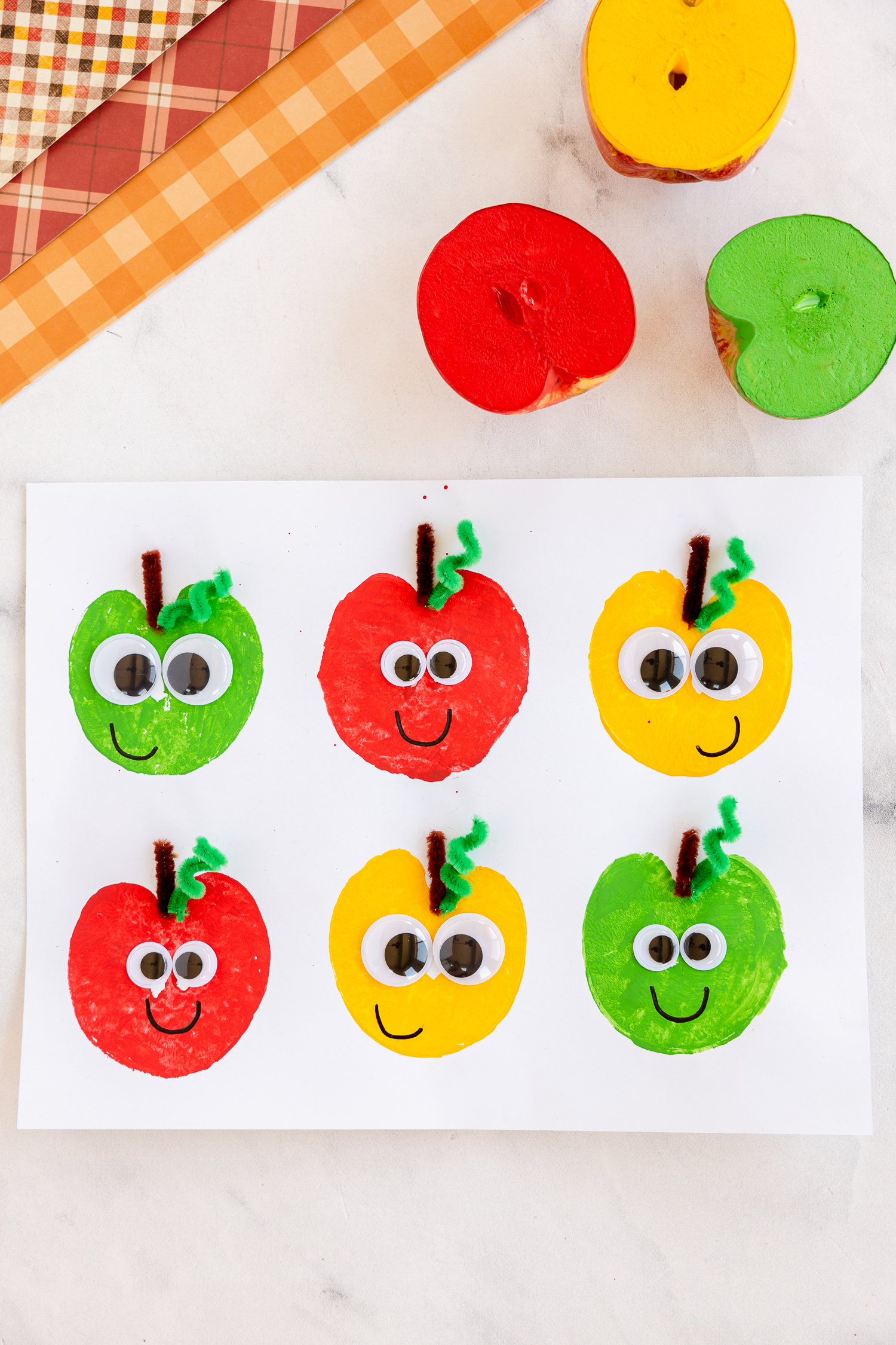 Red, green and yellow apple stamped prints on white paper