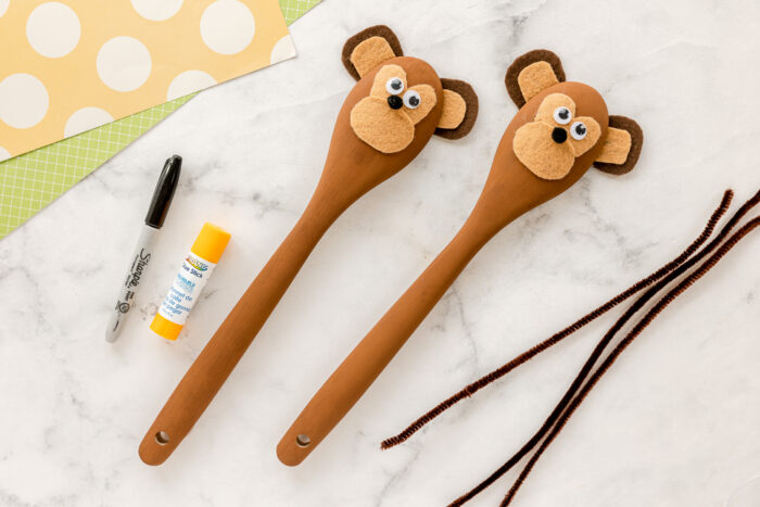 googly eyes, pom poms added to wooden spoon