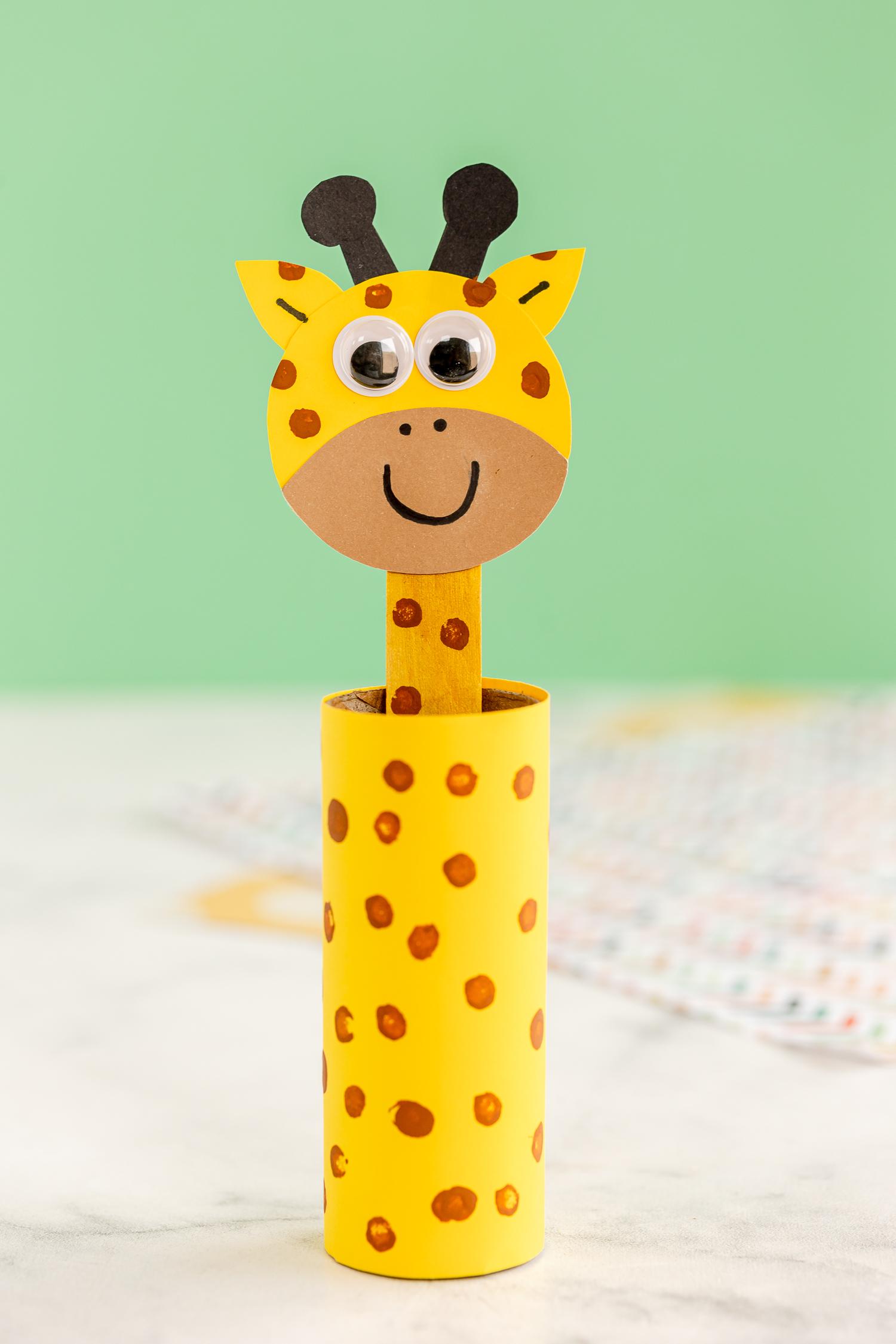 toilet paper roll giraffe on counter with light green background