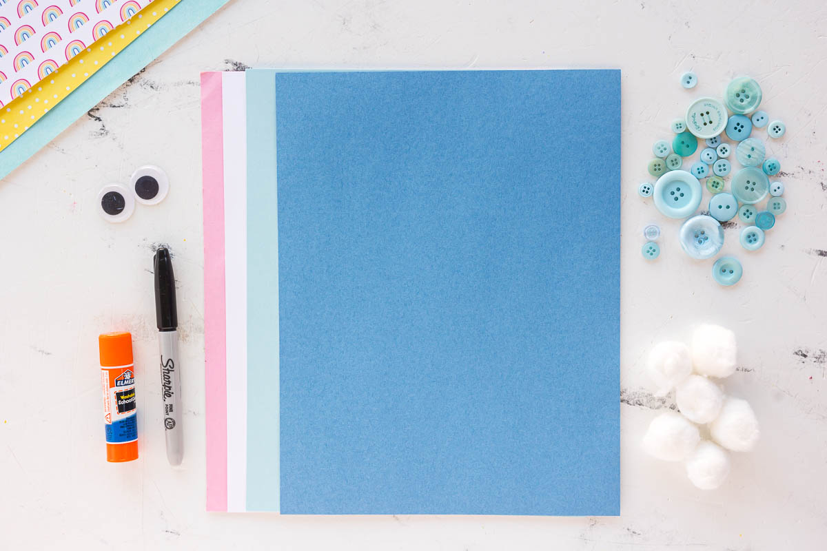 Supplies needed for a rain cloud craft including printable template, cardstock, buttons, cotton balls, string, scissors, and glue