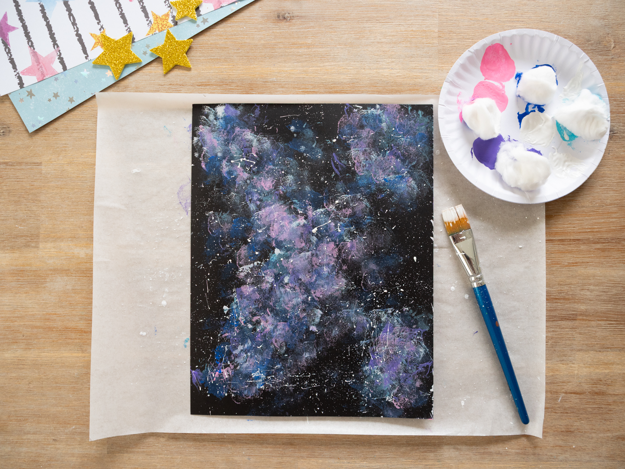 adding white paint splatter stars to galaxy painting