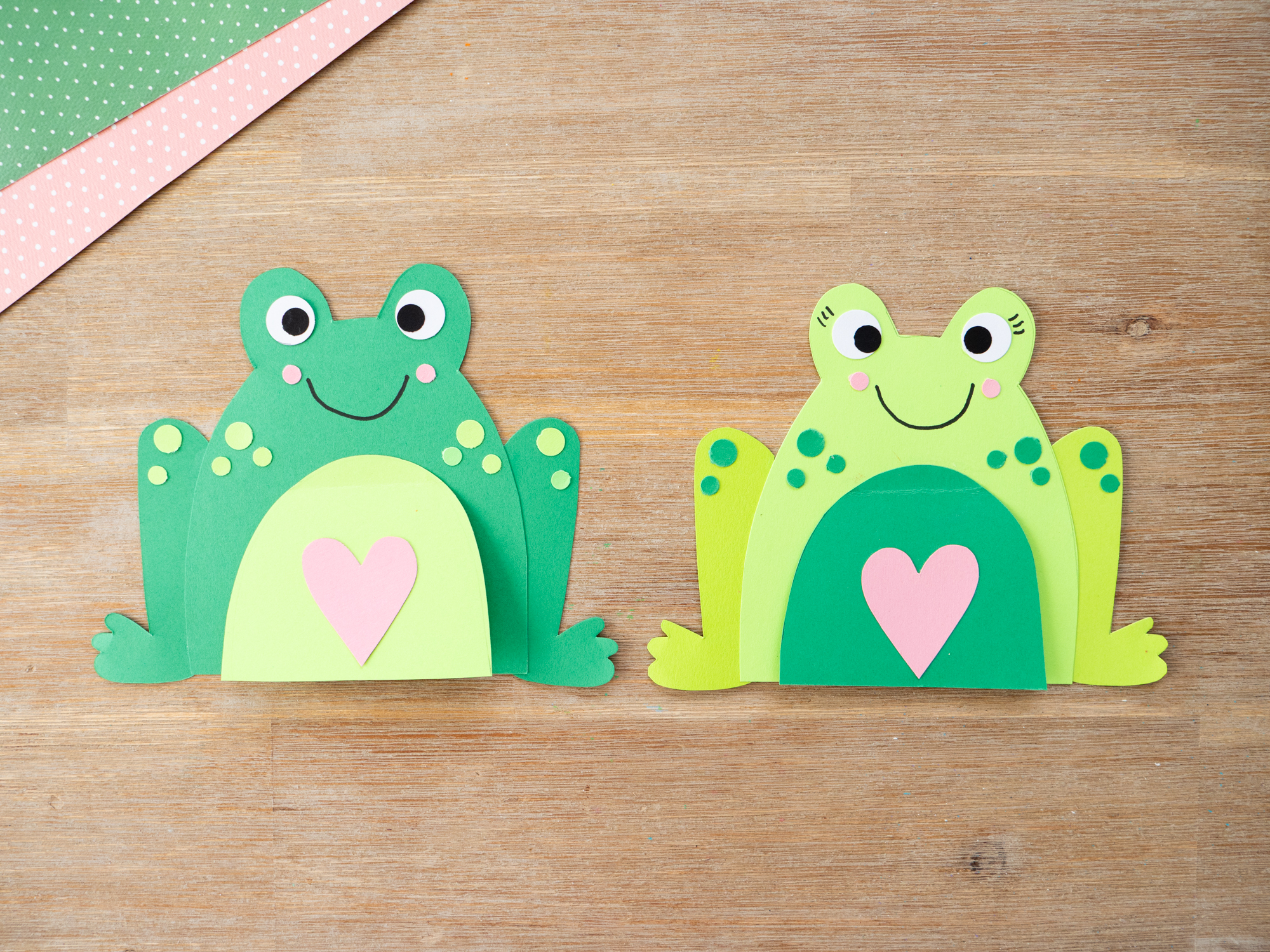 Using a hole punch to create circles for decorating a frog craft card
