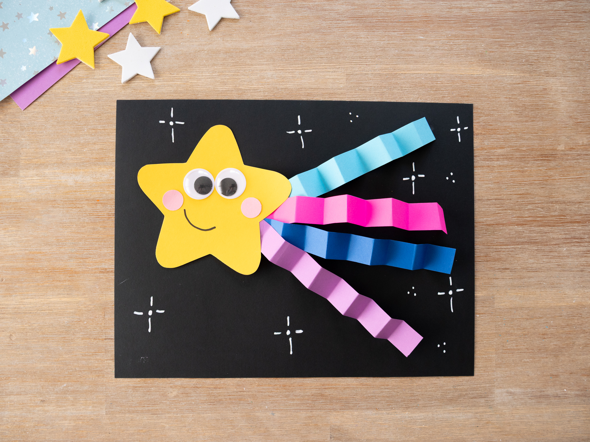 adding white paint marker stars to black paper background