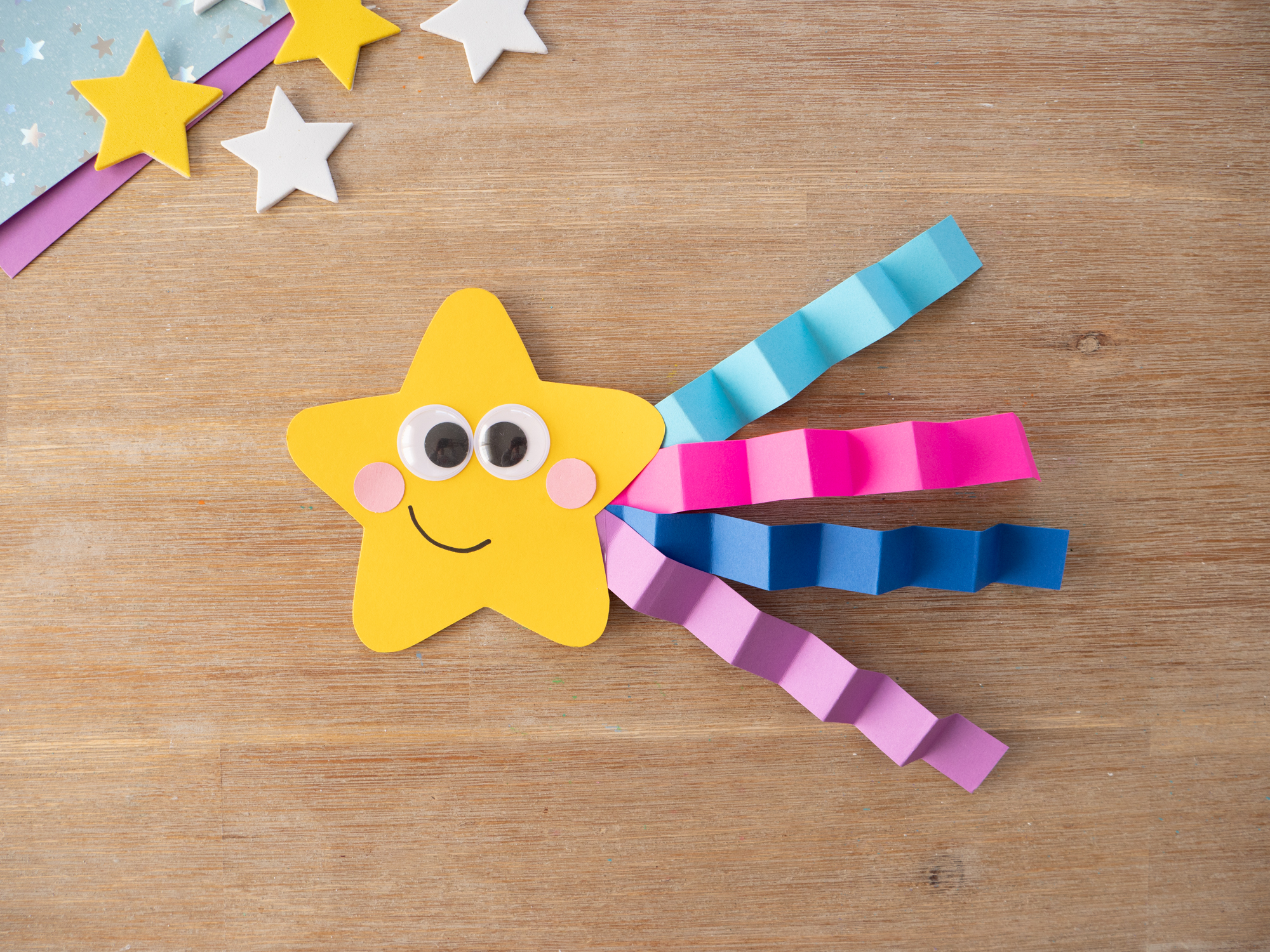 assembling a paper shooting star craft with streamers