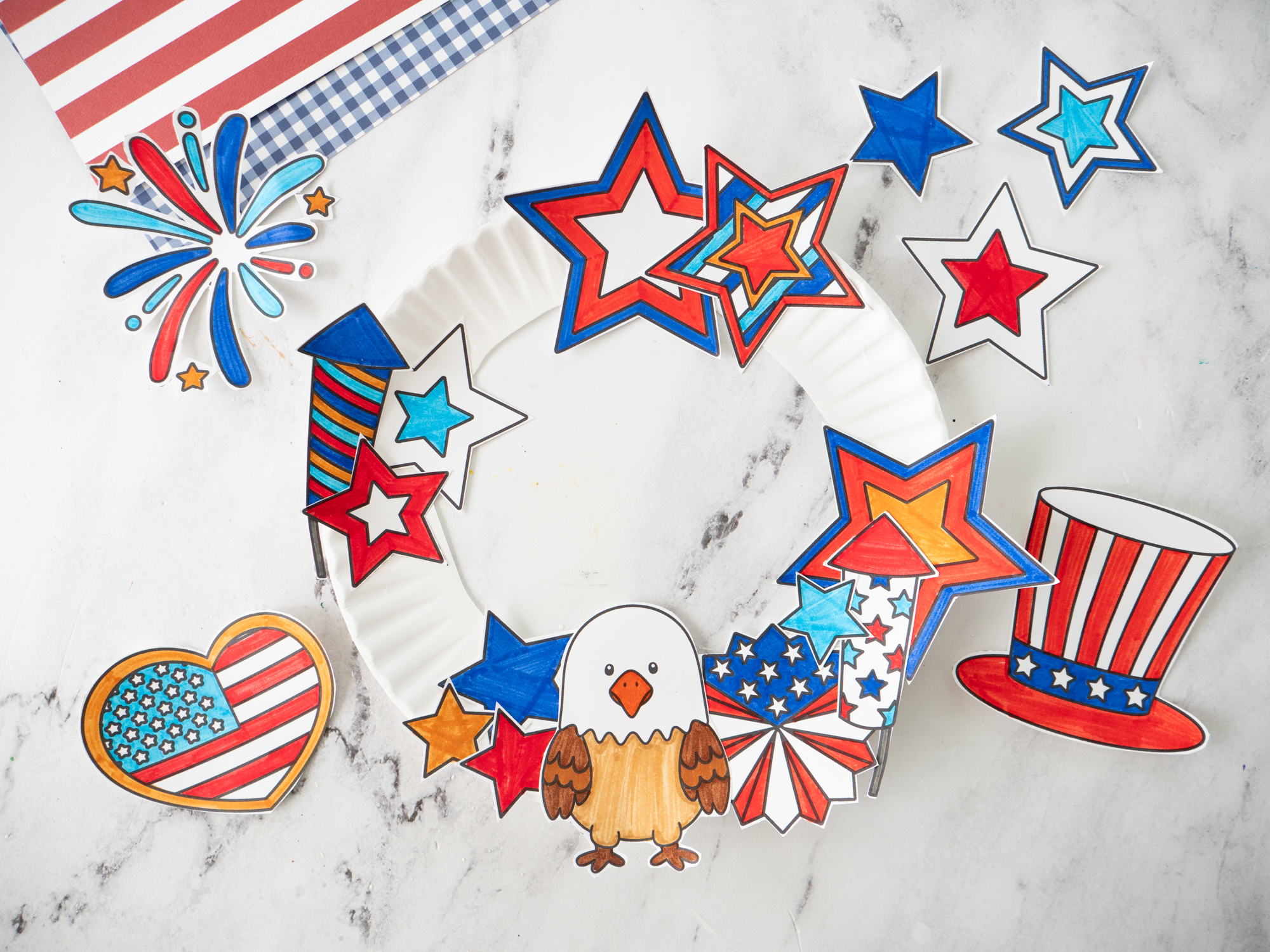 Gluing patriotic printable decorations onto a paper plate Fourth of July wreath